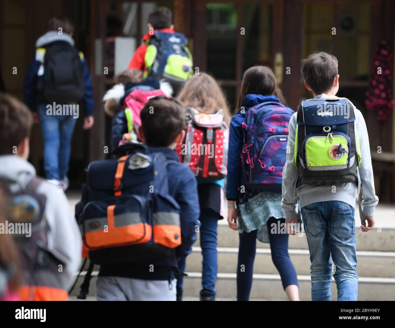 Wiesbaden, Deutschland. Juni 2020. Schüler der vierten Klasse der Robert Schumann Grundschule gehen nacheinander vom Schulhof in das Schulgebäude. Am 22. Juni starten die Hessischen Grundschulen wieder mit dem gemeinsamen Präsenzunterricht für alle Kinder. Die Distanzregel gilt dann nicht mehr. Kredit: Arne Dedert/dpa/Alamy Live News Stockfoto