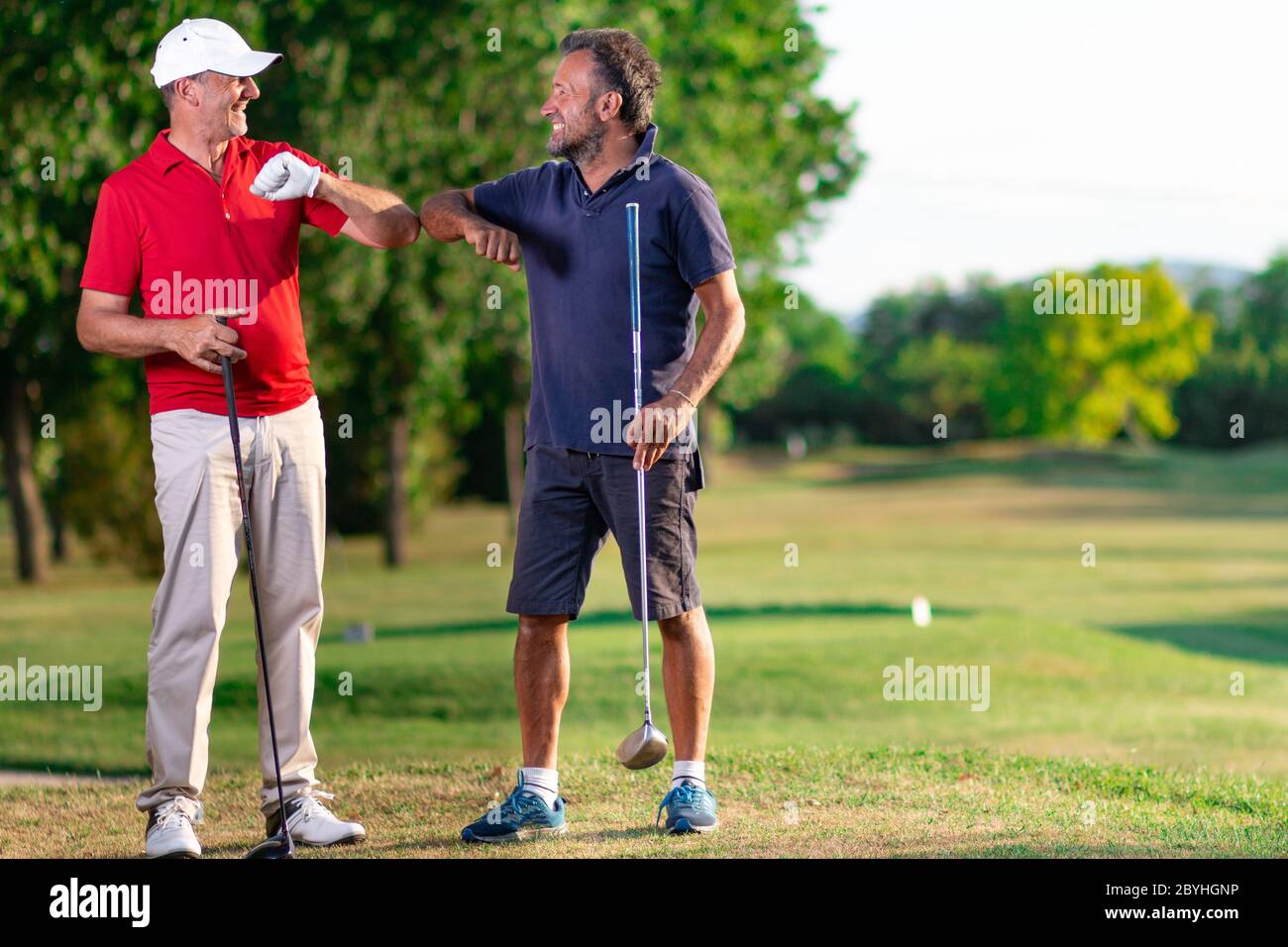 Zwei Golfer grüßen sich gegenseitig, indem sie ihre Ellbogen berühren -  Golffreunde grüßen uns zum Zeitpunkt des Covid Stockfotografie - Alamy