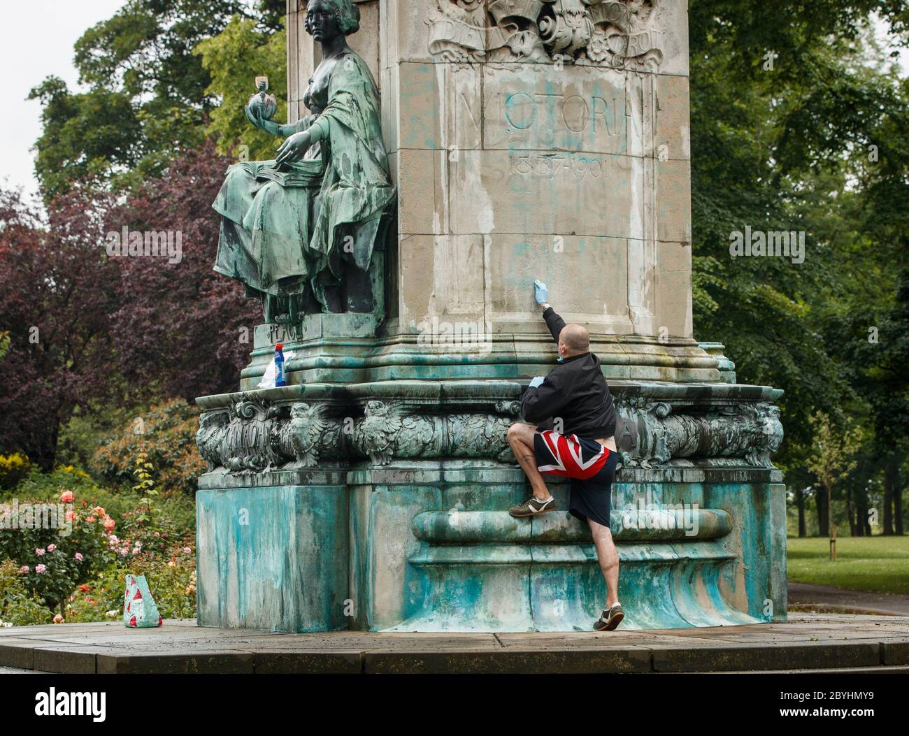 Graham Newby, Mitglied der Öffentlichkeit, reinigt Graffiti, darunter die Buchstaben BLM und die Worte "Wanderer" und "Eigentümer der Lave", von einer Statue von Königin Victoria in Woodhouse Moor, Leeds, nach einer Reihe von Black Lives Matter Protesten, die am Wochenende in ganz Großbritannien stattfanden. Die Proteste wurden durch den Tod von George Floyd ausgelöst, der am 25. Mai in Polizeigewahrsam in der US-Stadt Minneapolis getötet wurde. Stockfoto