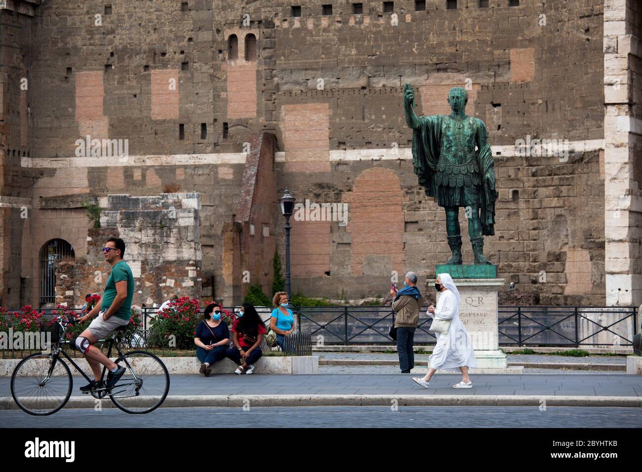 Italien Wiedereröffnung, Start Phase 3. Personen, die eine Schutzmaske tragen, gehen am Dienstag, den 02. Juni 2020 in Rom in der Straße Fori Imperiali nahe dem Kolosseum (Colosseo) umher. Stockfoto