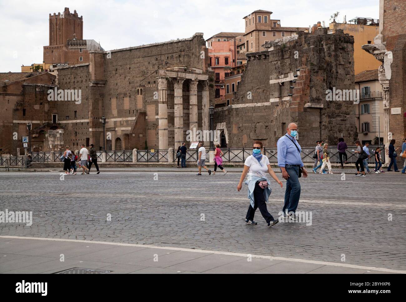 Italien Wiedereröffnung, Start Phase 3. Personen, die eine Schutzmaske tragen, gehen am Dienstag, den 02. Juni 2020 in Rom in der Straße Fori Imperiali nahe dem Kolosseum (Colosseo) umher. Stockfoto