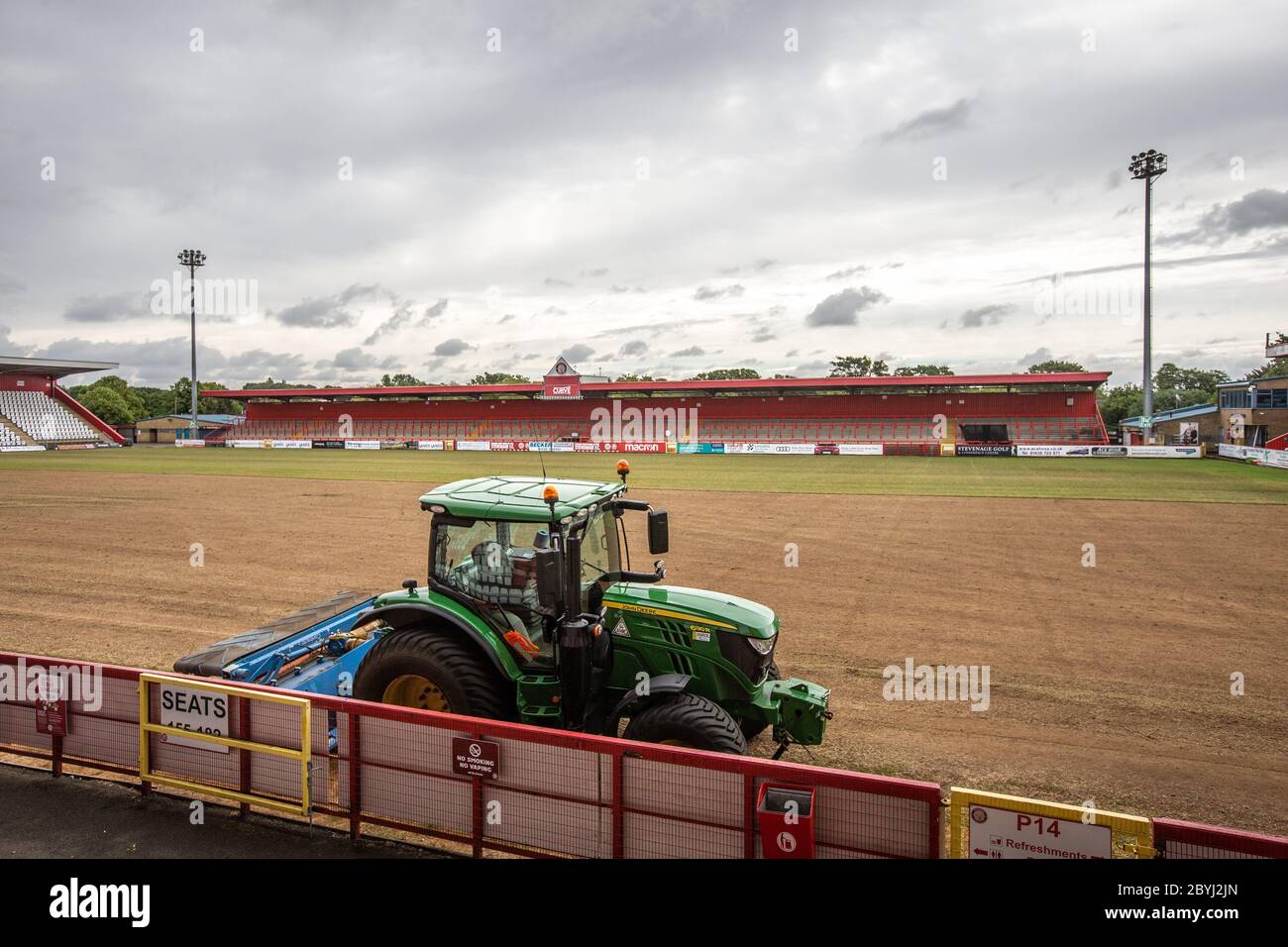 Traktor auf Fußball / Fußballplatz auf Sportplatz während der Saisonende Arbeit von Bodenpersonal Umlagerung Rasen. Stockfoto