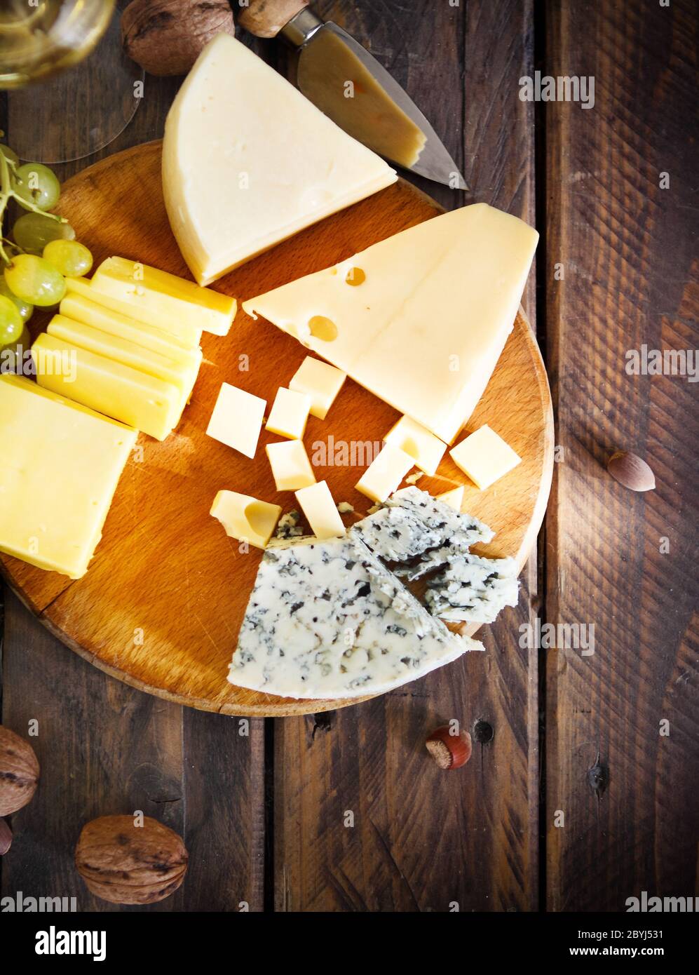 Glas Weißwein, Käse, Nüssen und Trauben Stockfoto
