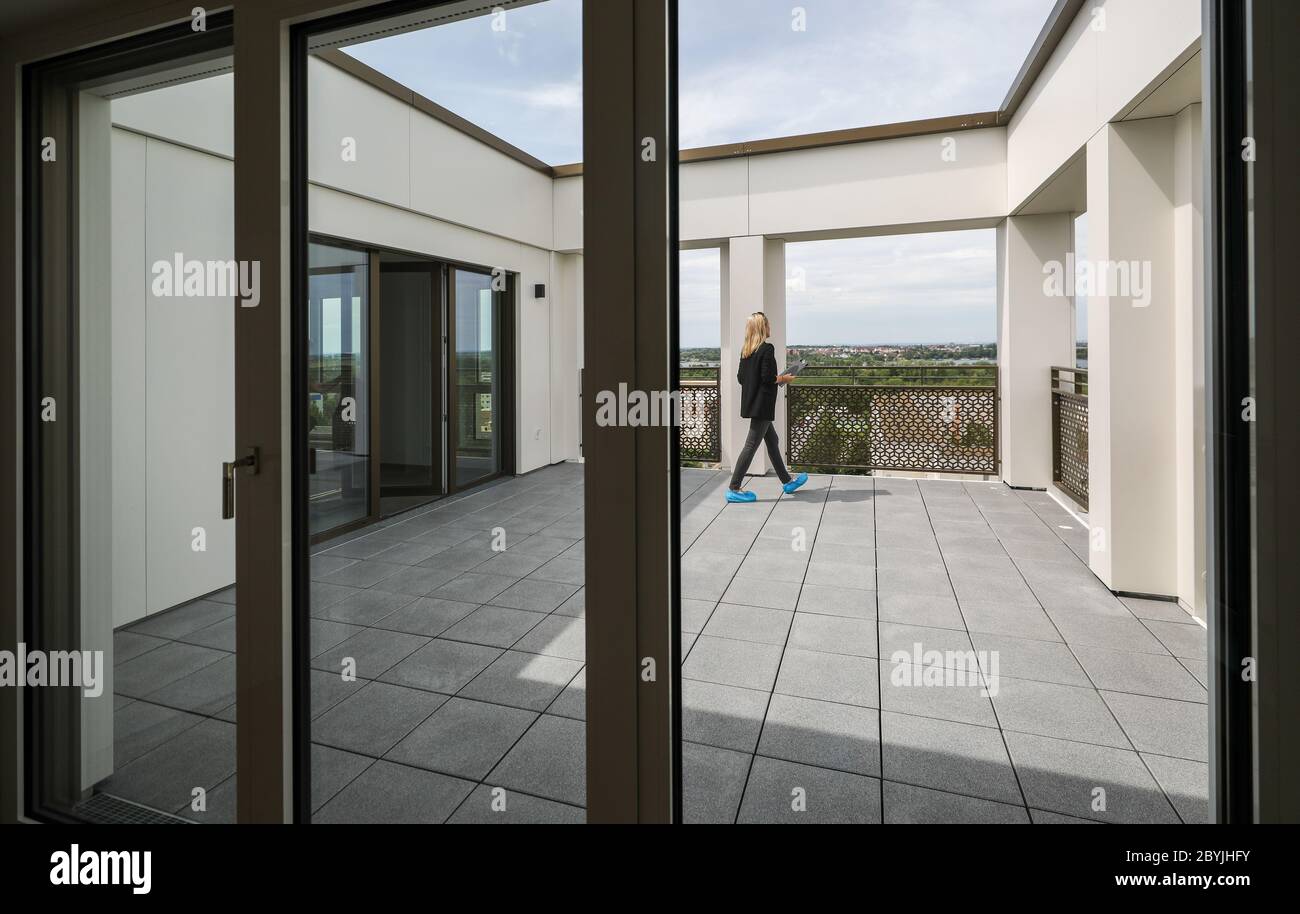 Leipzig, Deutschland. Juni 2020. Ein Mitarbeiter der Wohnungsgenossenschaft geht über den Balkon einer Wohnung im neuen Lipsienturm. Das erste Hochhaus nach der Wiedervereinigung im Leipziger DDR-Plattenbau Grünau bietet auf 13 Etagen Platz für 60 ein- bis Dreizimmerwohnungen. Gut 13 Millionen Euro investiert die Wohnungsgenossenschaft Lipsia. Das barrierefreie Projekt "Lipsia Tower" richtet sich in erster Linie an ältere Mieter. Nach den aktuellen Plänen sollen die ersten Bewohner im Juli einziehen. Quelle: Jan Woitas/dpa-Zentralbild/dpa/Alamy Live News Stockfoto