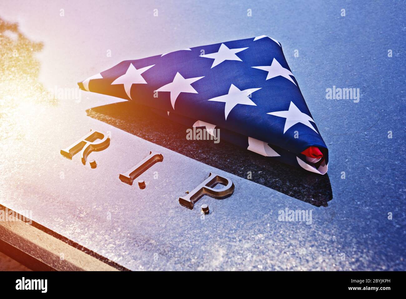 Gefaltet in Dreieck amerikanische Flagge auf Gedenkstein Marmorgrab mit R.I.P. Text. Die Fahnenfaltung ist eine Art und Weise, an besonderen Tagen, wie Memorial, die Flagge zu ehren Stockfoto