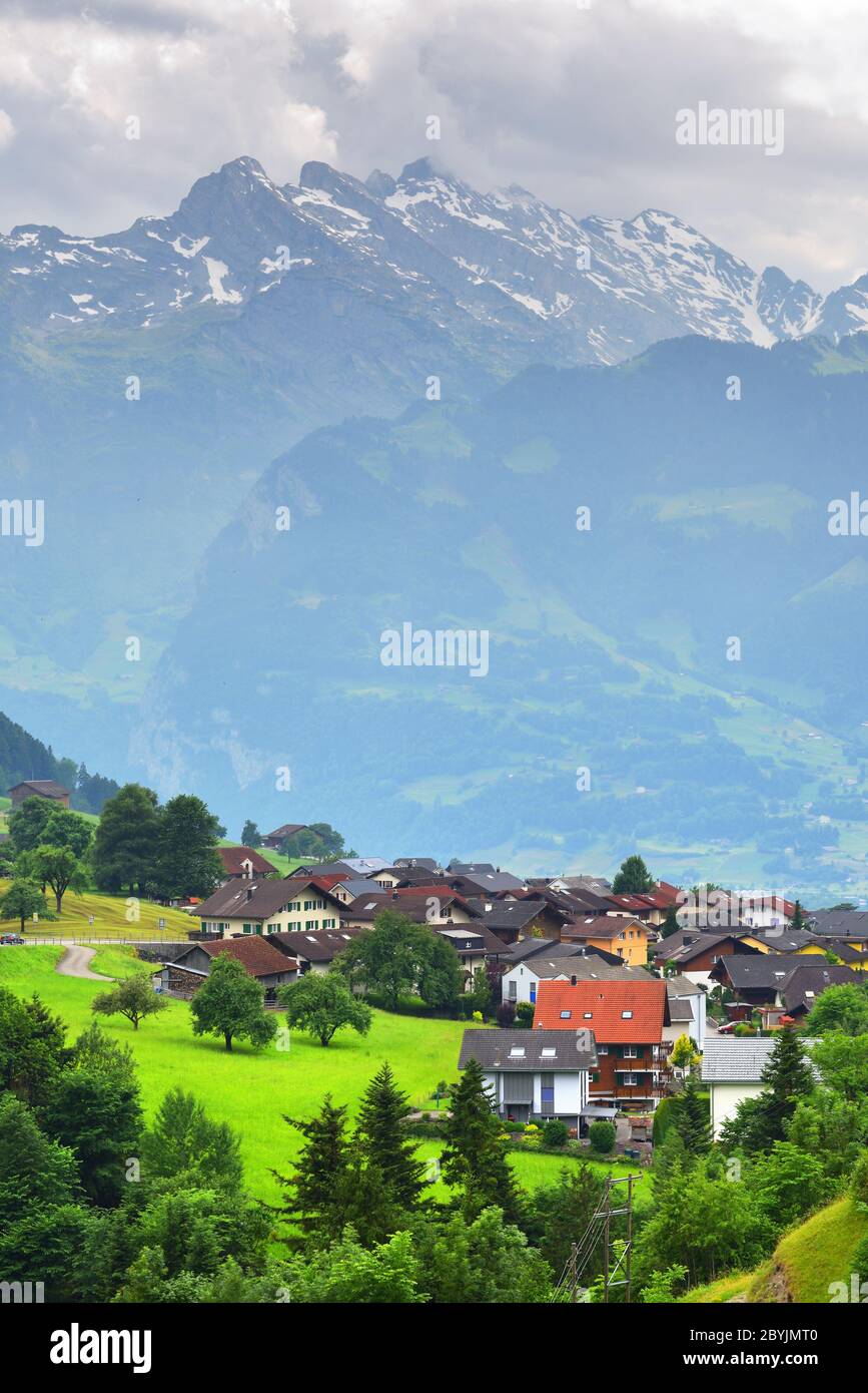 Schöner Blick auf idyllische Bergkulisse in den Alpen mit traditionellen Chalets in frischen grünen Almwiesen im Kanton Uri bei Altdorf, Schweiz Stockfoto