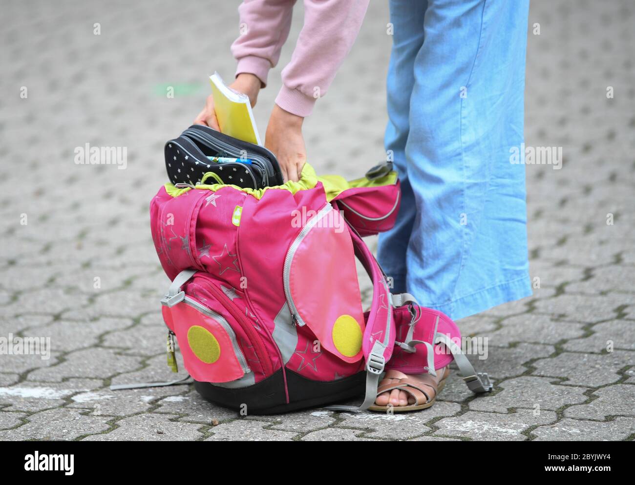 Wiesbaden, Deutschland. Juni 2020. Eine Schülerin der vierten Klasse der Robert Schumann Grundschule packt im Schulhof ein Notizbuch in ihre Tasche. Kredit: Arne Dedert/dpa/Alamy Live News Stockfoto