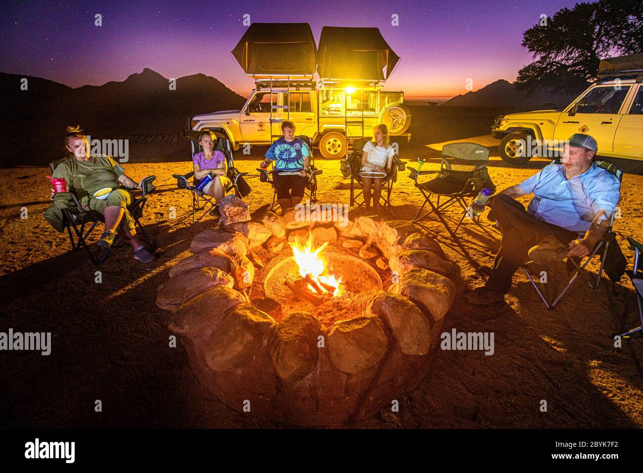 Alle versammeln sich am Lagerfeuer für ein warmes Essen und etwas Entspannung, Helmeringhausen, Namibia Stockfoto
