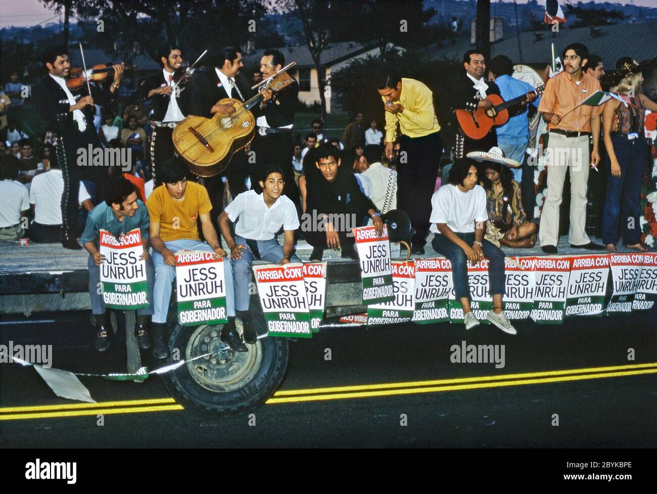 Ein Festwagen in einer Parade der Chicano Gemeinde in Los Angeles, Kalifornien, USA 1970 (Chicanos und Chicanas sind Männer und Frauen mexikanischer Abstammung). Plakate zeigen die Unterstützung in der Gemeinde für Jess Uruh in seinem Antrag für Staatsgouverneur in diesem Jahr. Ebenfalls auf dem Float ist eine Mariachi Band und Sängerin. Jesse Marvin Unruh (1922–1987) war ein amerikanischer demokratischer Politiker und der California State Treasurer. Unruh kämpfte erfolglos für Gouverneur von Kalifornien gegen Ronald Reagan. Stockfoto