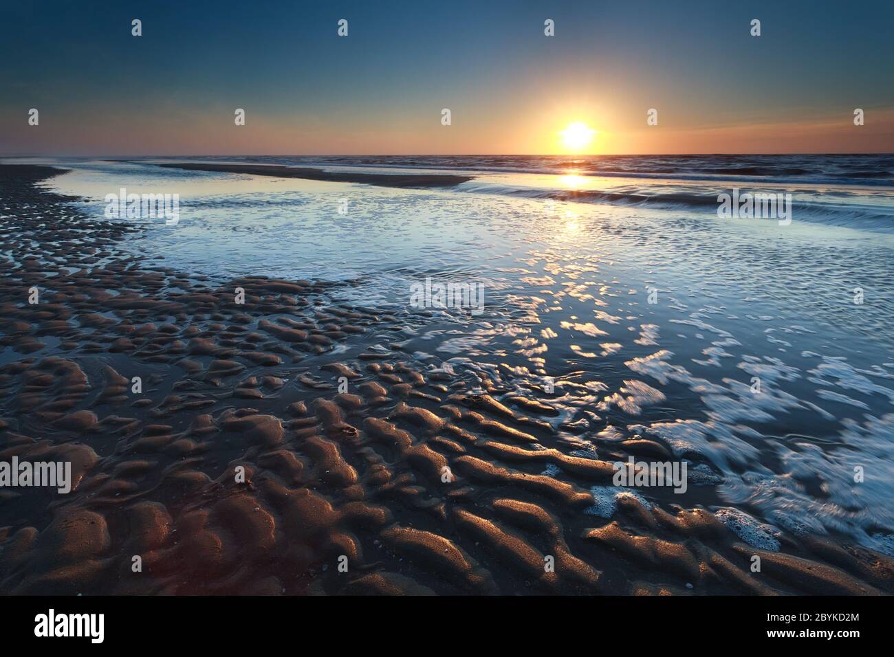 Gold Sonnenuntergang über Nordsee Sandstrand bei Ebbe Stockfoto