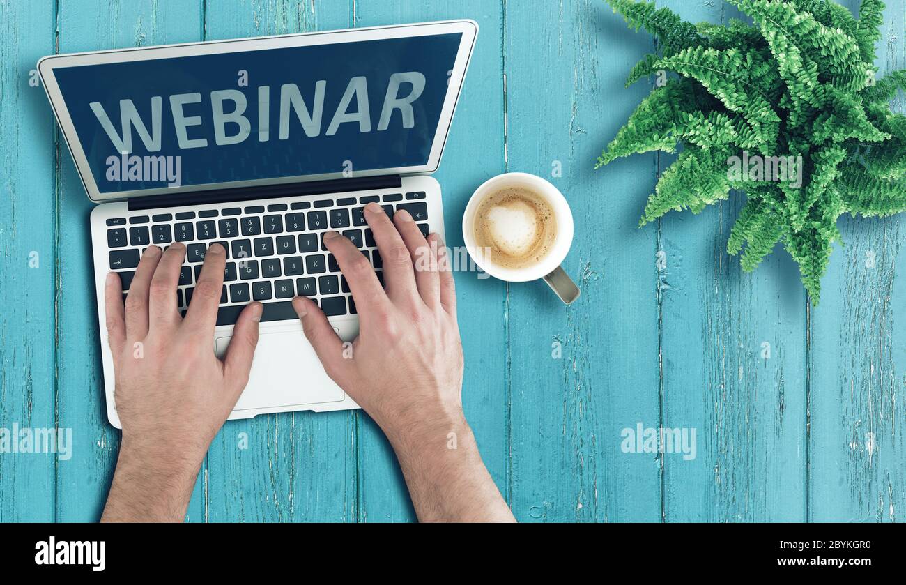 Oben Ansicht der Person, die Laptop-Computer auf Holztisch, um an Webinar, Online-Bildung und E-Learning-Konzept teilnehmen Stockfoto