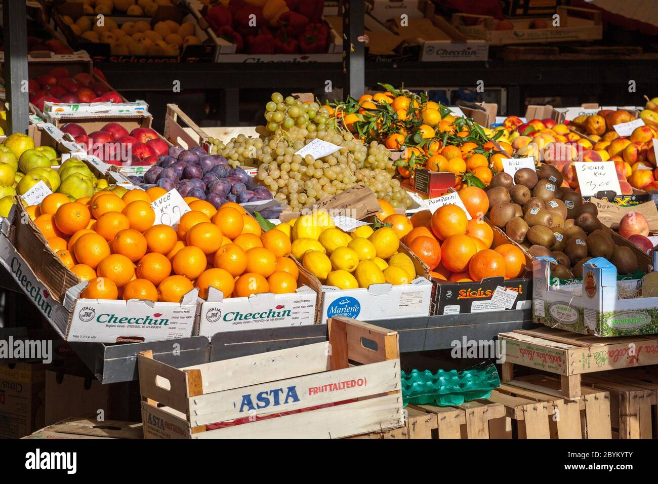 Hell erleuchtet von Sonnenschein frisches Obst in Kisten und Tabletts einige mit Preistickets zum Verkauf am Mercato Rialto in Venedig, Italien Stockfoto