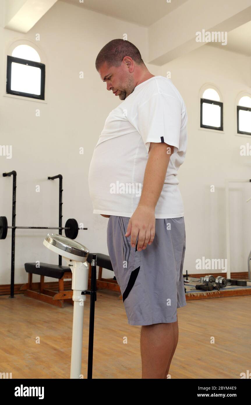 Mann mit Übergewicht auf Waage im Fitnessstudio Stockfotografie - Alamy