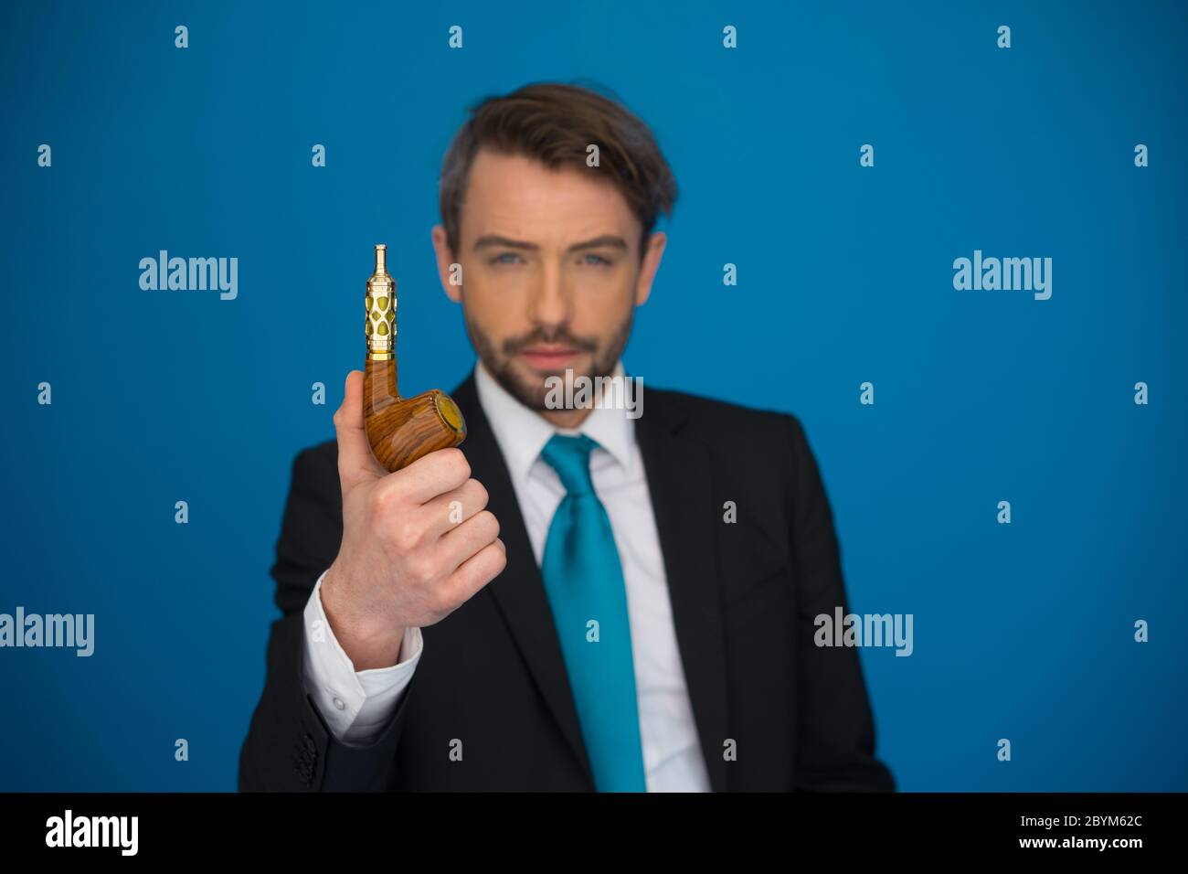 Geschäftsmann mit e-Zigarette tragen Anzug und Krawatte auf blau Stockfoto