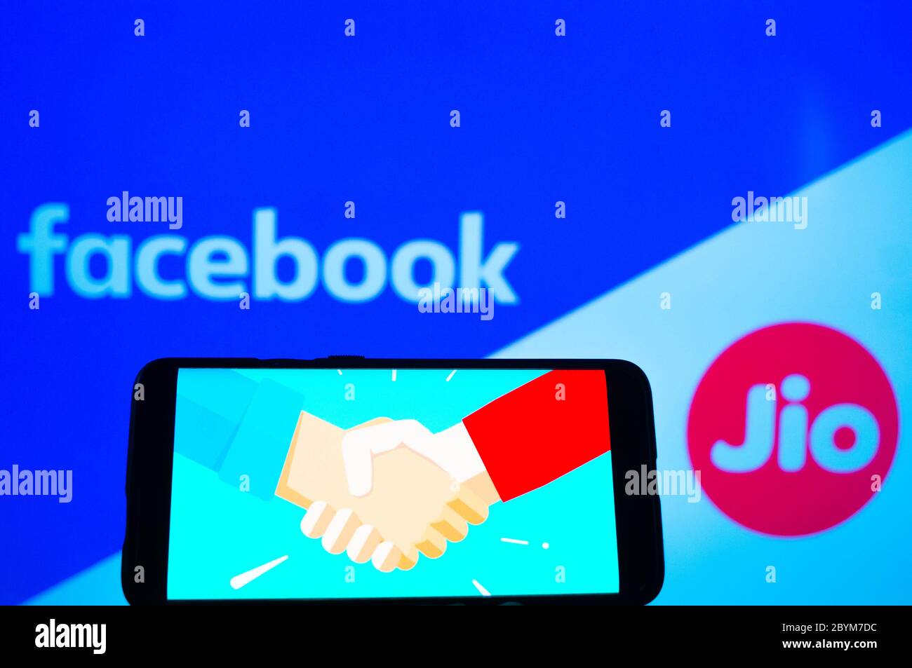 Handy mit Handshake-Bildschirm und facebook und jio im Hintergrund Stockfoto