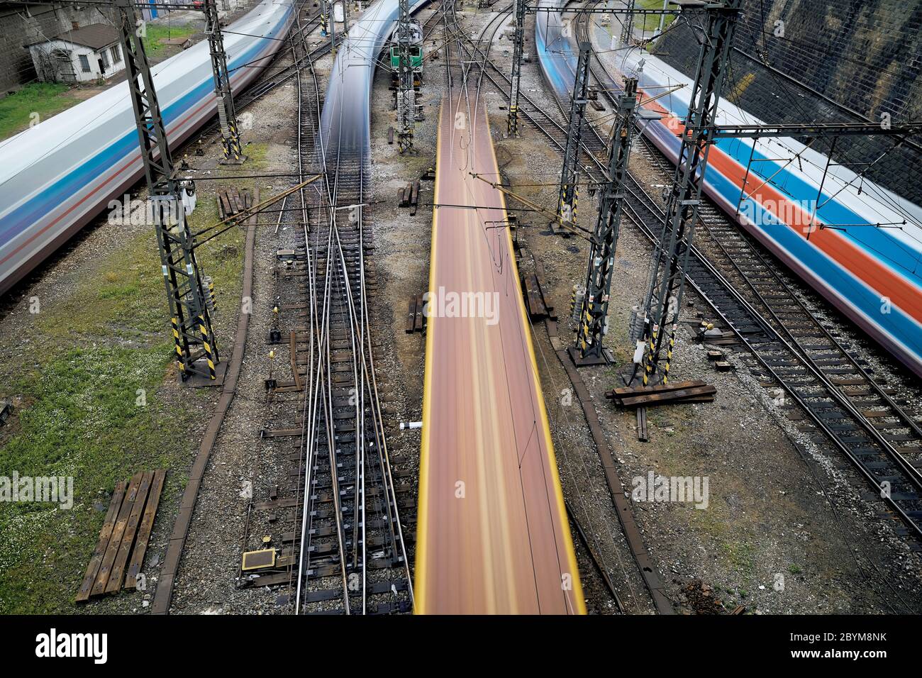 Verschwommene Bewegung der Züge im belebten Bahnhof. Themen Schienenverkehr, Verbindung und Geschwindigkeit. Stockfoto