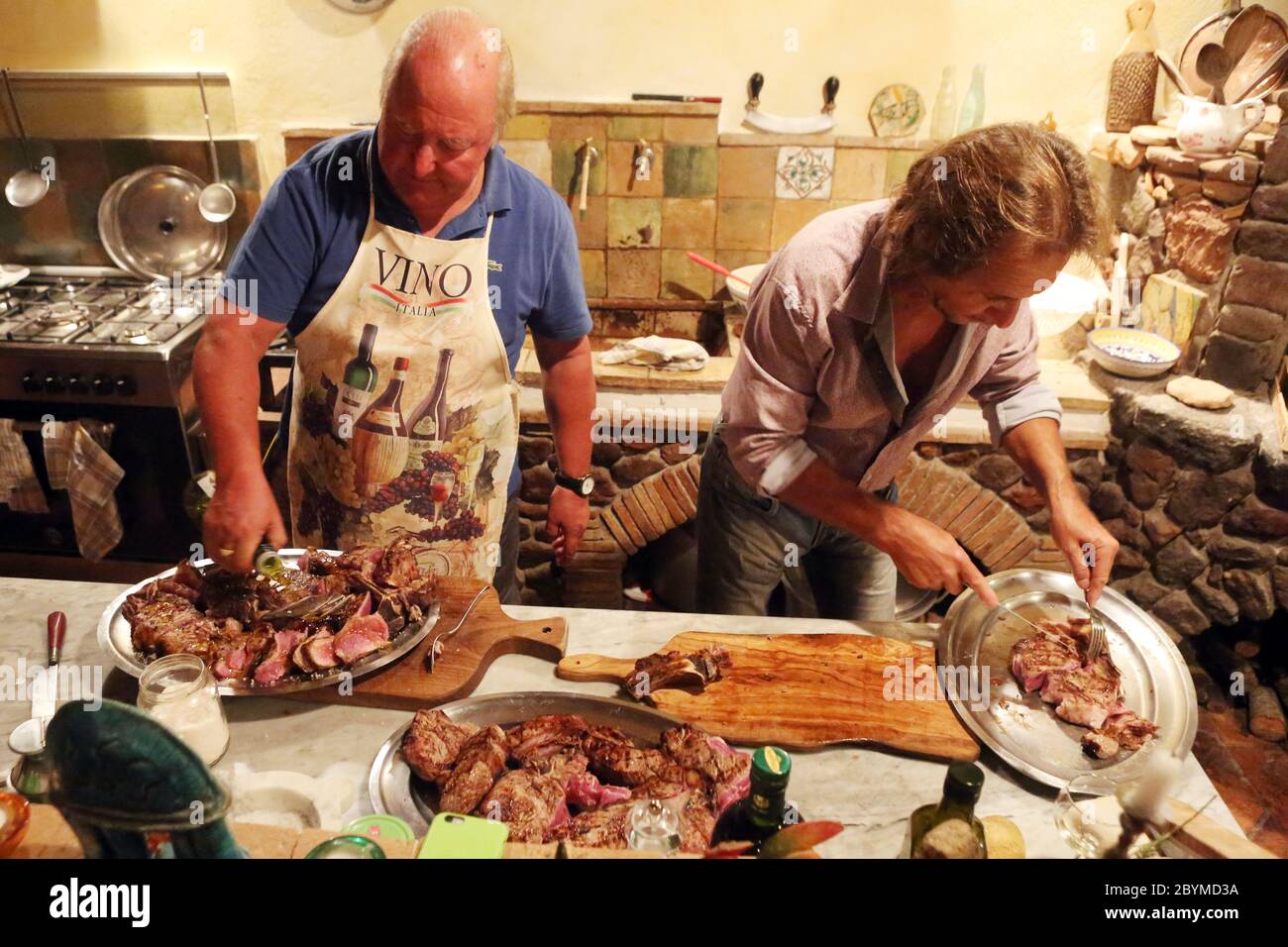 01.08.2016, Pomantello, Viterbo, Italien - die Männer bereiten Steaks auf Silbertabletts zu. 00S160801D009CAROEX.JPG [MODEL RELEASE: NEIN, PROPERTY RELEASE: NO (C) CARO Stockfoto