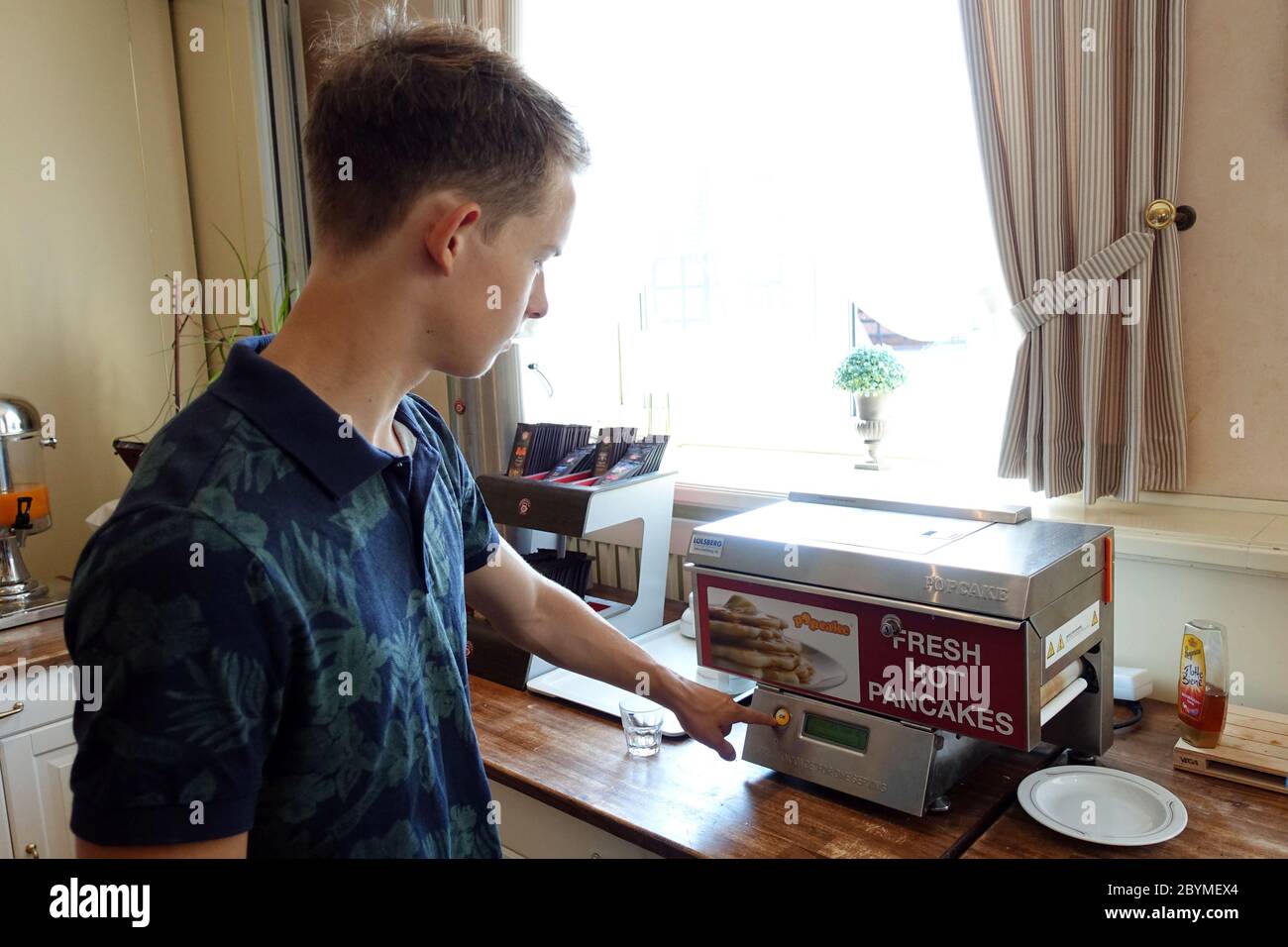 23.06.2019, Langenhagen, Niedersachsen, Deutschland - Boy bereitet Pfannkuchen zum Frühstück mit einem Automaten. 00S190623D021CAROEX.JPG [MODELLFREIGABE: Y Stockfoto