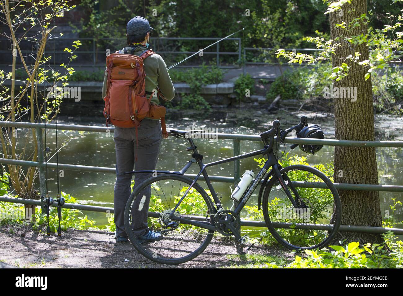 Mann, der während der Coronavirus-Pandemie in Brooklyn, New York, vom Weg entlang der Wasserstraße im Prospect Park angeln kann. Stockfoto