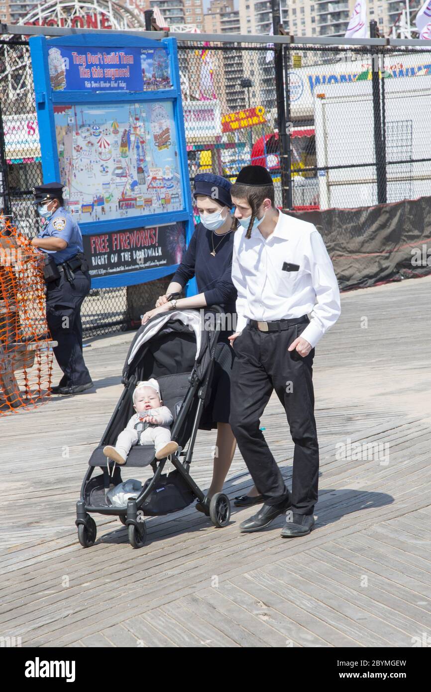 Junge orthodoxe jüdische Familie geht auf der Promenade auf Coney Island und bekommt während der Covid-19 Coronavirus-Pandemie etwas Sonne und Luft. Brooklyn, New Y Stockfoto