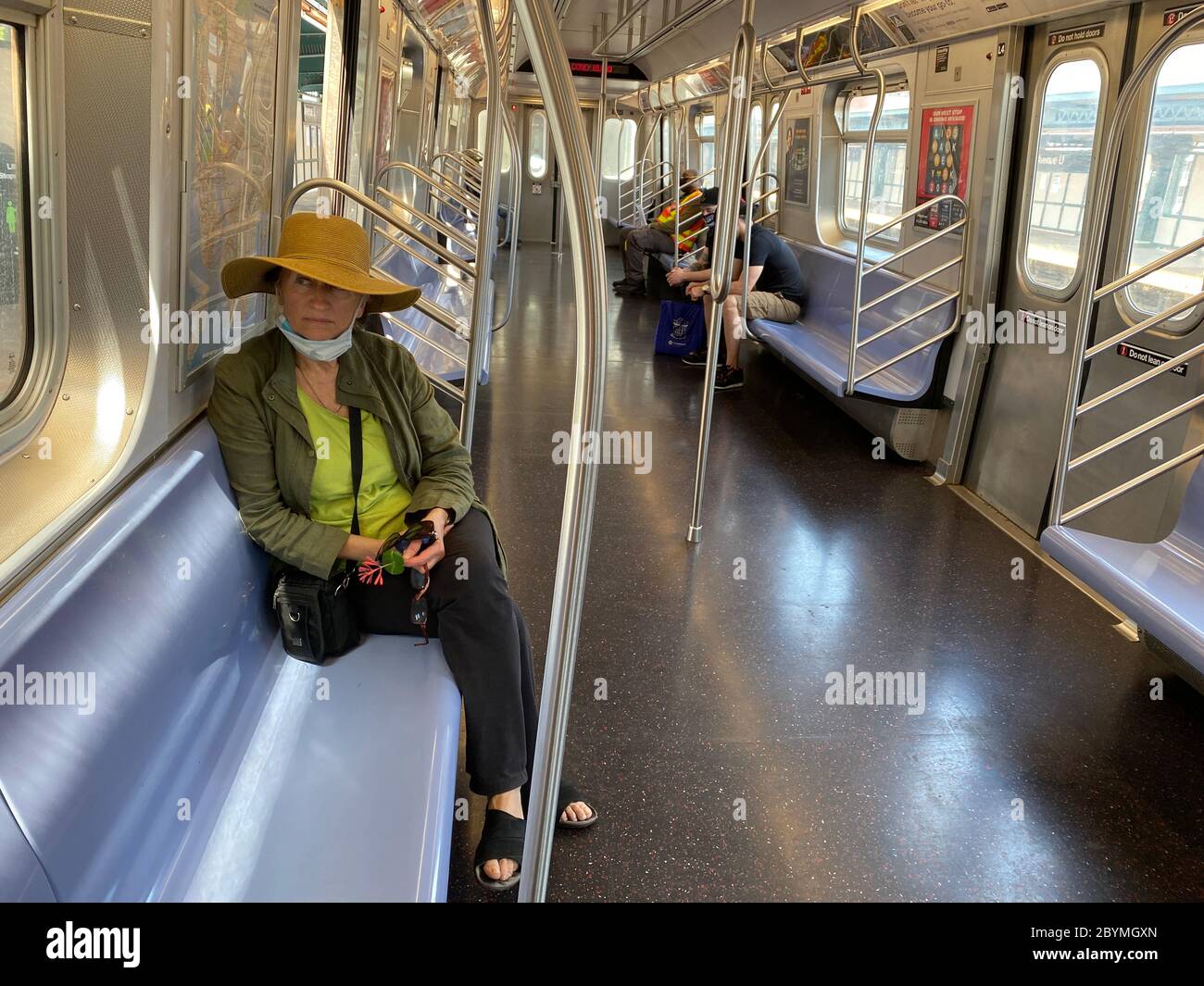 Frau fährt während der Covid-19-Pandemie in Brooklyn, NY, mit einer meist leeren U-Bahn. Stockfoto