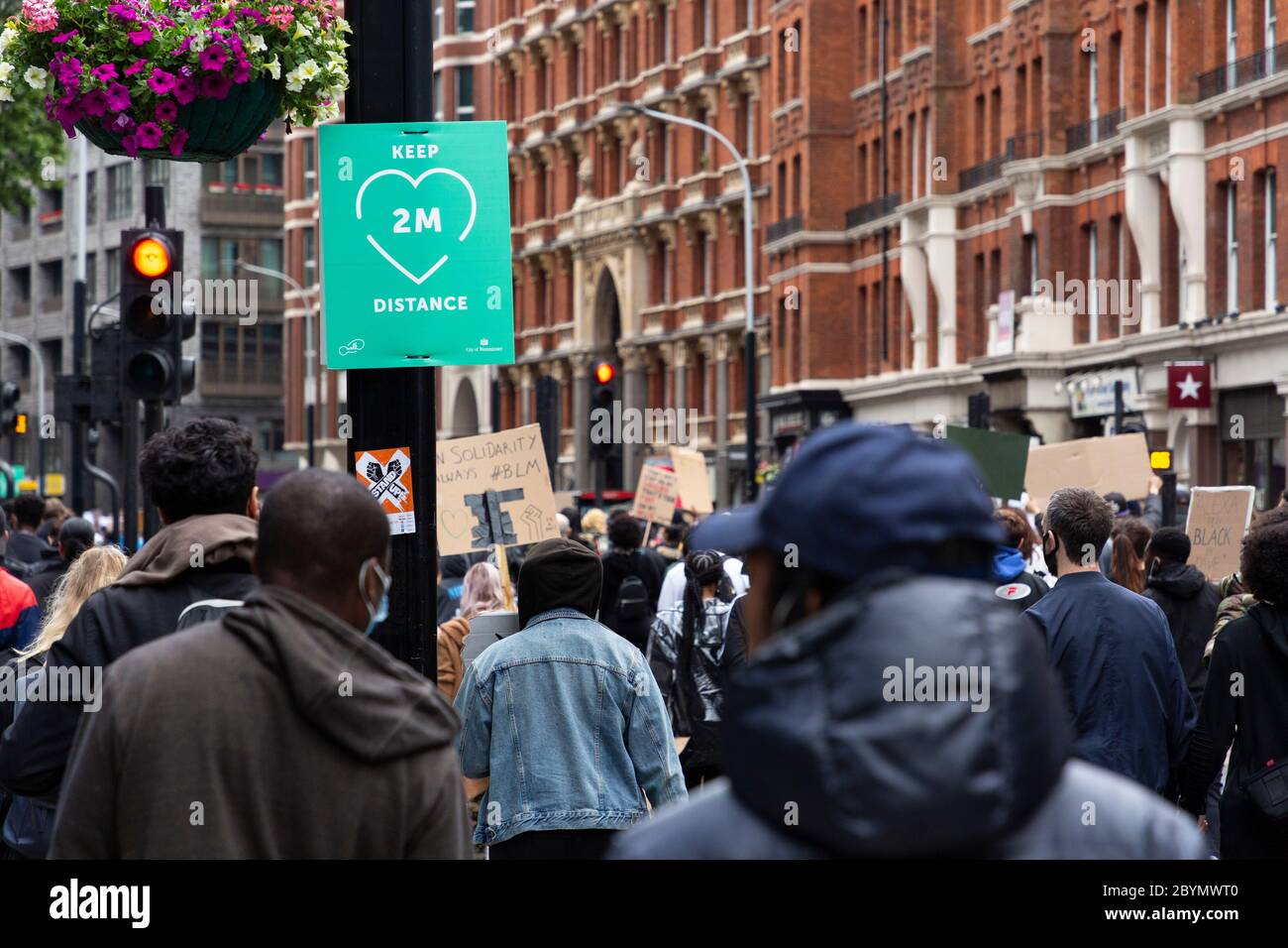 Eine Menge Demonstranten marschiert während eines Black Lives Matters Protests an einem sozial distanzierenden Zeichen vorbei, London, 7. Juni 2020 Stockfoto