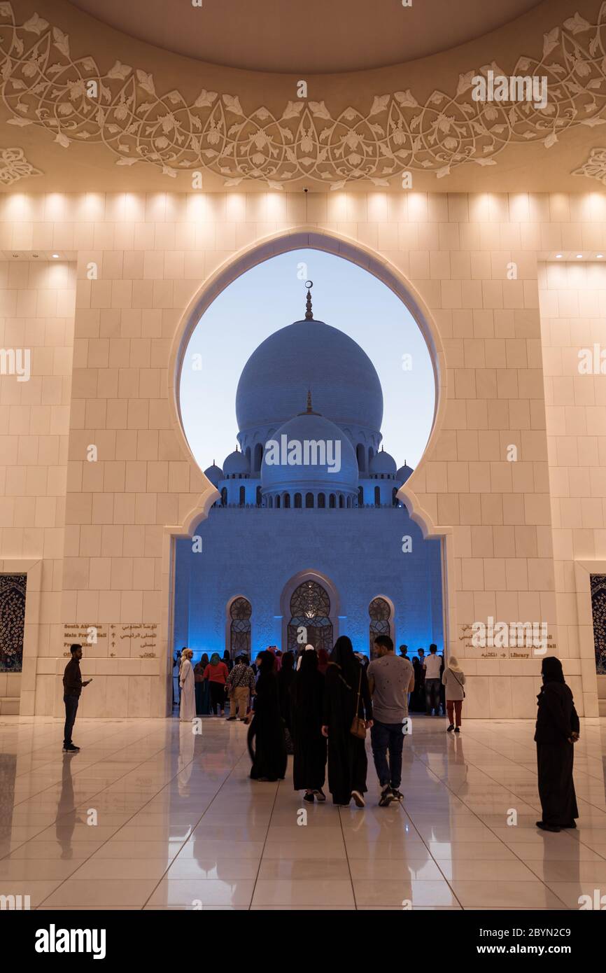 Abu Dhabi / Vereinigte Arabische Emirate - 5. Februar 2020: Große Gruppe von Touristen unter dem Bogentor in der Scheich-Zayed-Moschee Stockfoto