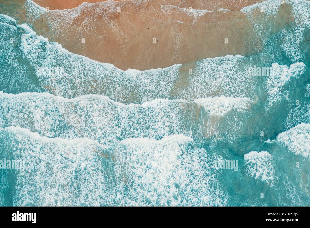 Luftaufnahme von tropischen Sandstrand und das blaue Meer. Blick von oben auf die Wellen des Ozeans erreichen Ufer auf sonnigen Tag. Palawan, Philippinen. Stockfoto