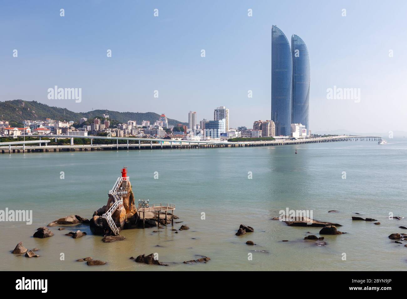 Stadtbild von Xiamen mit Wolkenkratzern (Shimano Straits Towers) und einem Leuchtturm. Stockfoto