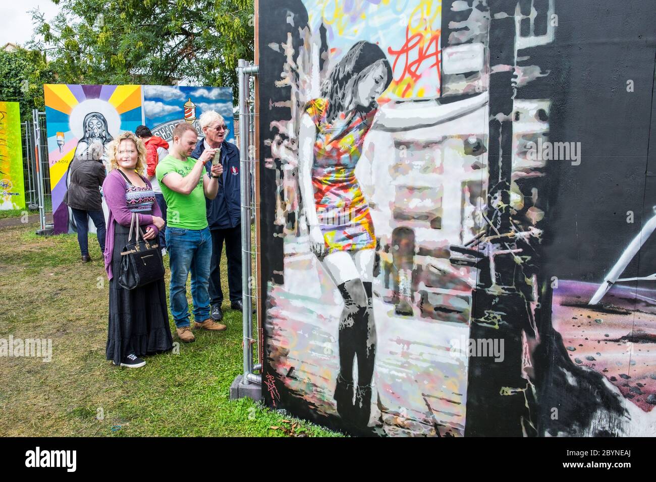 Die Menschen werden in Bedminster, Bristol, beim Upfest 2015, Europas größtem Street Art & Graffiti Festival, gemalte Kunstwerke gesehen Stockfoto