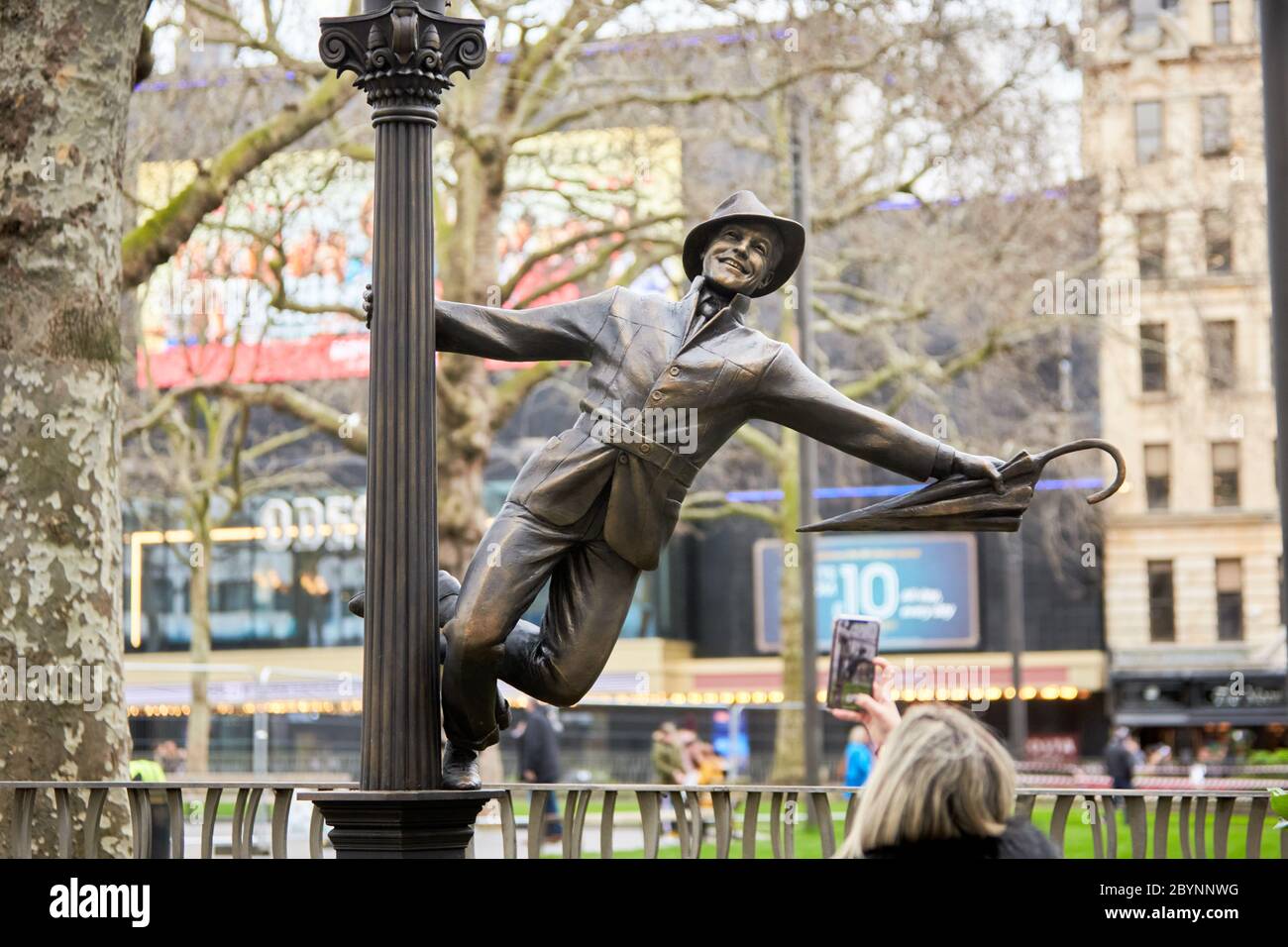 Statue von Gene Kelly in Singen in the Rain, Teil einer Reihe von Bronzeskulpturen zum Thema Film auf dem Leicester Square, die ein Jahrhundert des Kinos feiern Stockfoto