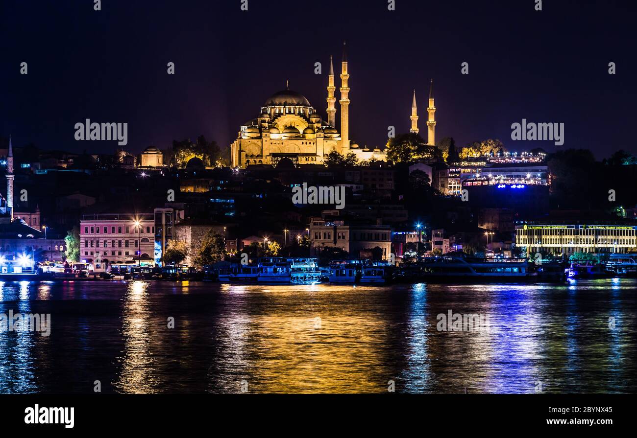 Nachtansicht auf die Restaurants am Ende der Galata Brücke, Sultanahmet, bei Sonnenuntergang mit der berühmten Suleymaniye Moschee in der Stockfoto