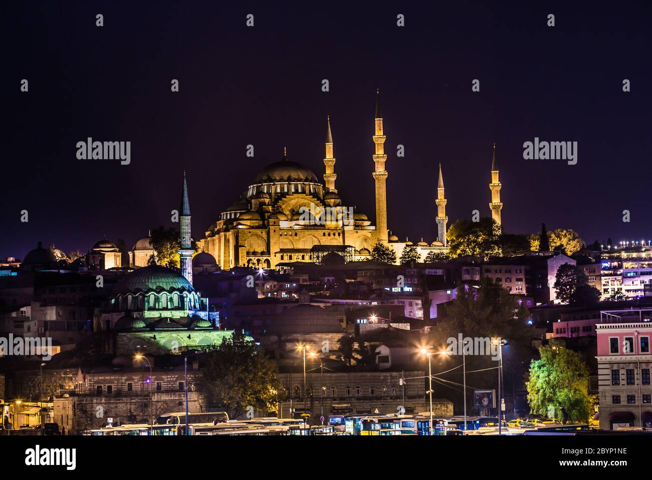 Nachtansicht auf die Restaurants am Ende der Galata Brücke, Sultanahmet, bei Sonnenuntergang mit der berühmten Suleymaniye Moschee in der Stockfoto
