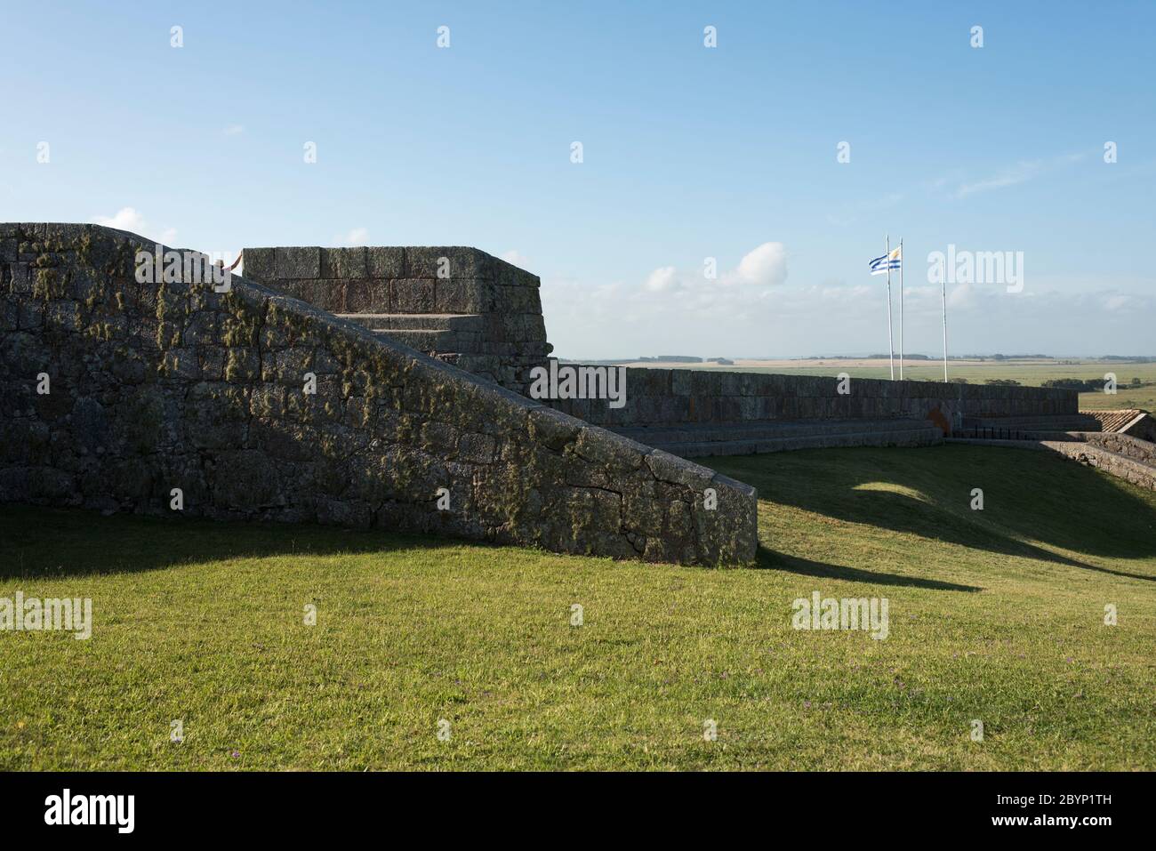 Innenraum der Festung von Santa Teresa, National Historic Monument, in Rocha, Uruguay, ein sonniger Sommernachmittag. Steinmauern und uruguayische Flagge wavi Stockfoto
