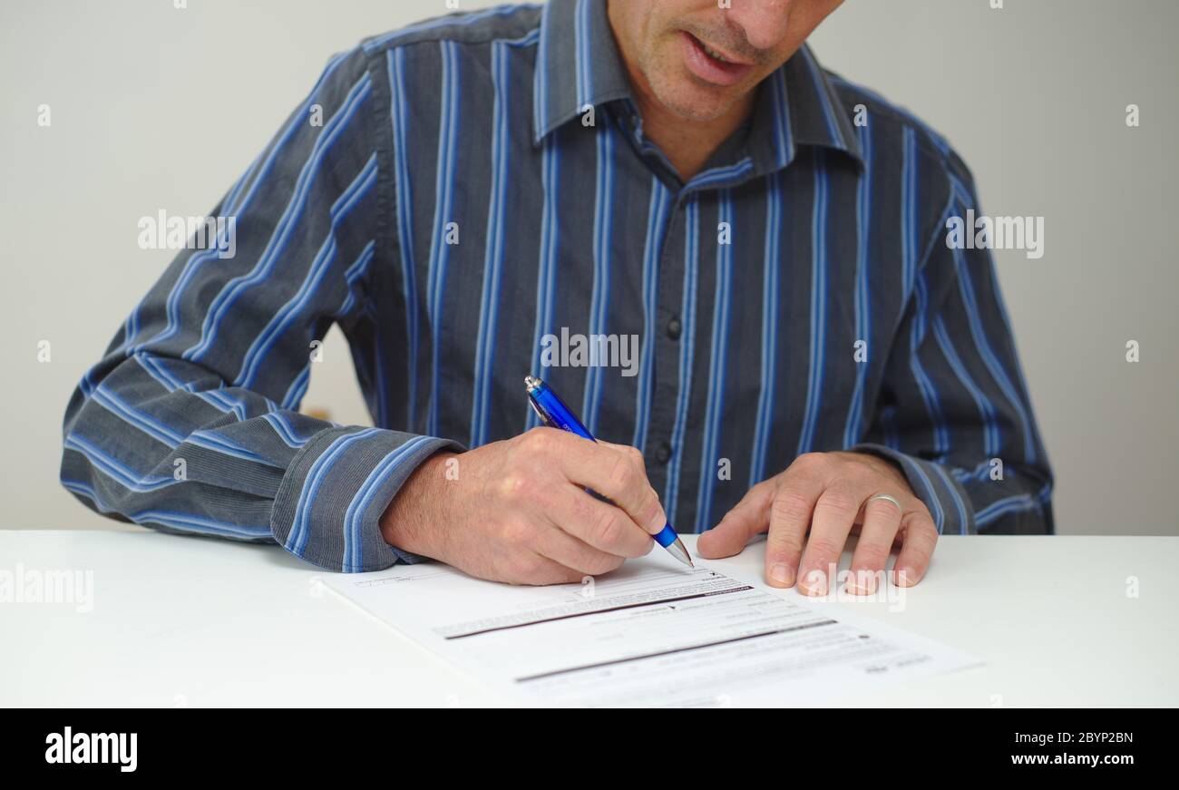 Mann, der im Begriff ist, ein offizielles gedrucktes Papierdokument zu unterzeichnen Stockfoto