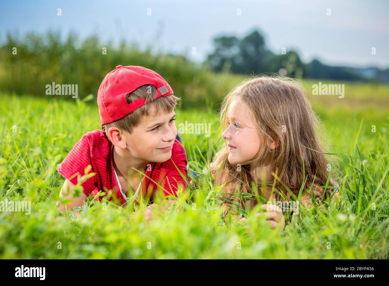 Cut Boy und ein Mädchen ruhen im Sommer auf dem grünen Gras Stockfoto