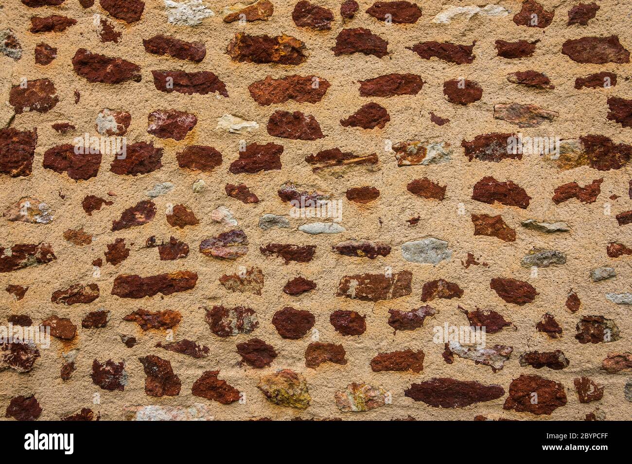 Detail der Mauer in Le Bouchet, die den roten Eisengehalt in dem lokalen Stein zeigt, Brenne, Indre, Frankreich. Stockfoto