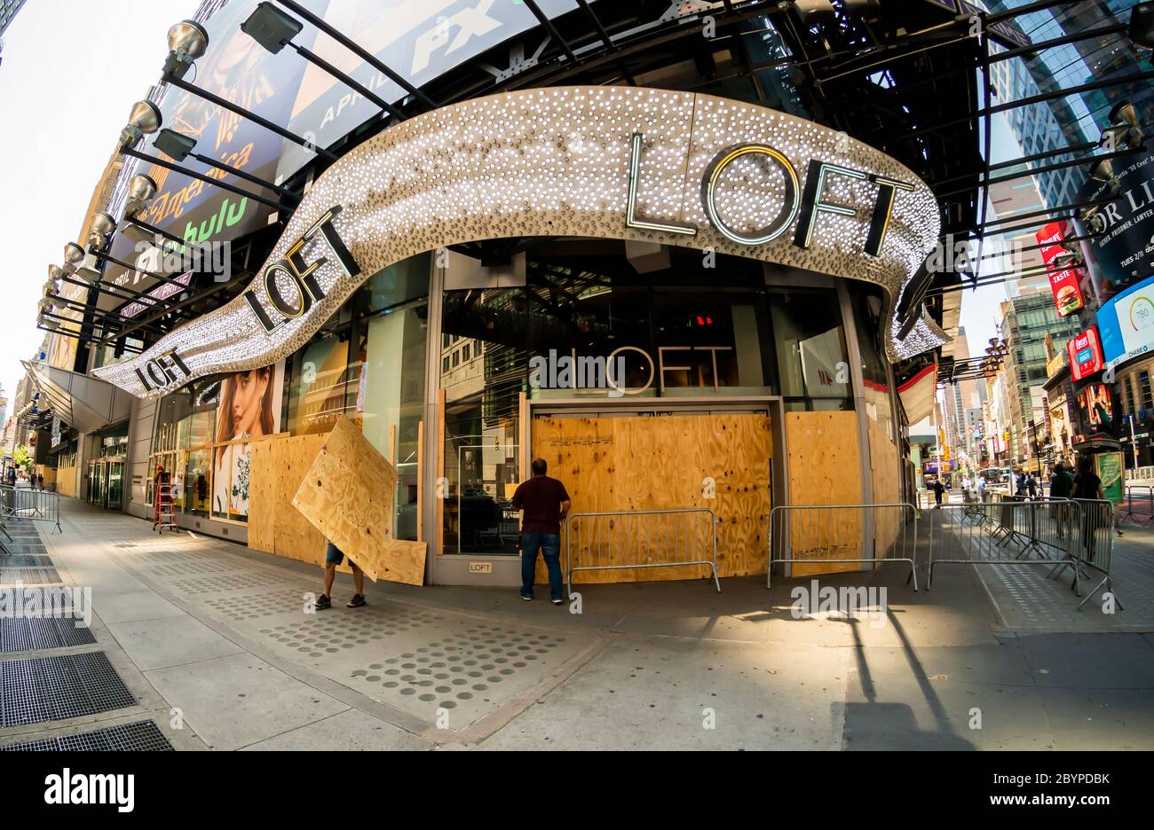 Arbeiter entfernen Sperrholz aus dem Loft-Laden am Times Square in New York am Dienstag, 9. Juni 2020 in Erwartung der Wiedereröffnung für Bordeseite Pick-up-Verkäufe. Die Stadt trat gestern offiziell in Phase 1 ihrer Wiedereröffnung ein. (© Richard B. Levine) Stockfoto