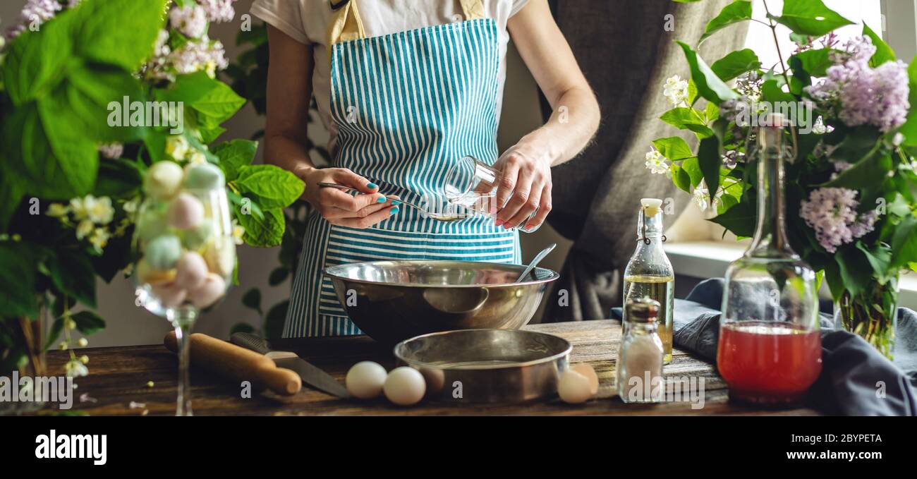 Eine Frau bereitet frischen Teig in gemütlicher Atmosphäre zu. Konzept der Zubereitung von leckeren Teiggerichten zu Hause. Stockfoto