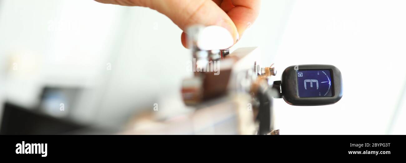 Tuning akustische oder elektrische Gitarre mit Gerät Stockfoto