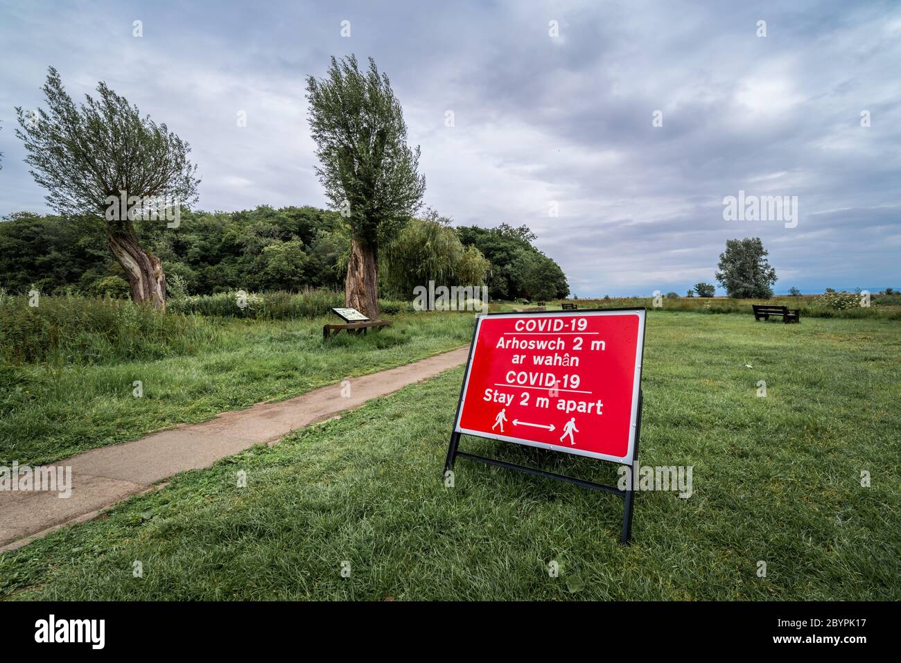 Zweisprachiges Covid-19-Zeichen in einem Landschaftspark in Wales Stockfoto