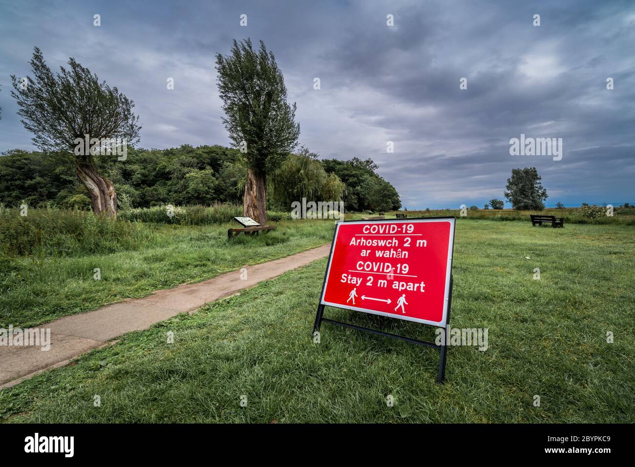 Zweisprachiges Covid-19-Zeichen in einem Landschaftspark in Wales Stockfoto