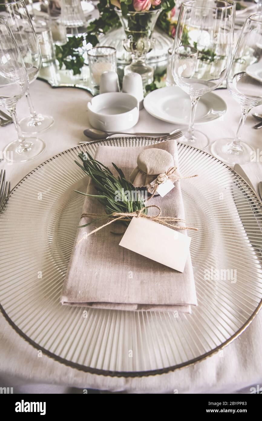 Nahaufnahme eines luxuriösen Hochzeitsempfangstisches im Freien auf dem Land; Kristallgeschirr und Leinenserviette Stockfoto