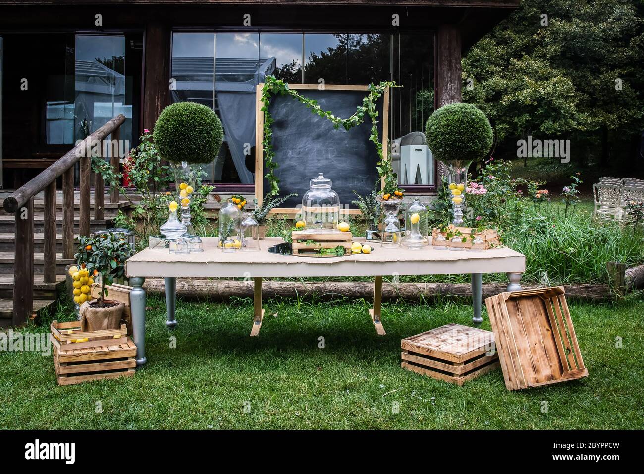 Eine luxuriöse Hochzeitsempfangsbar im Freien, Limonade-Bar auf dem Land,  eine leere Tafel, ein Getränkespender aus Glas, Vasen, Zitronen und Holz  Stockfotografie - Alamy