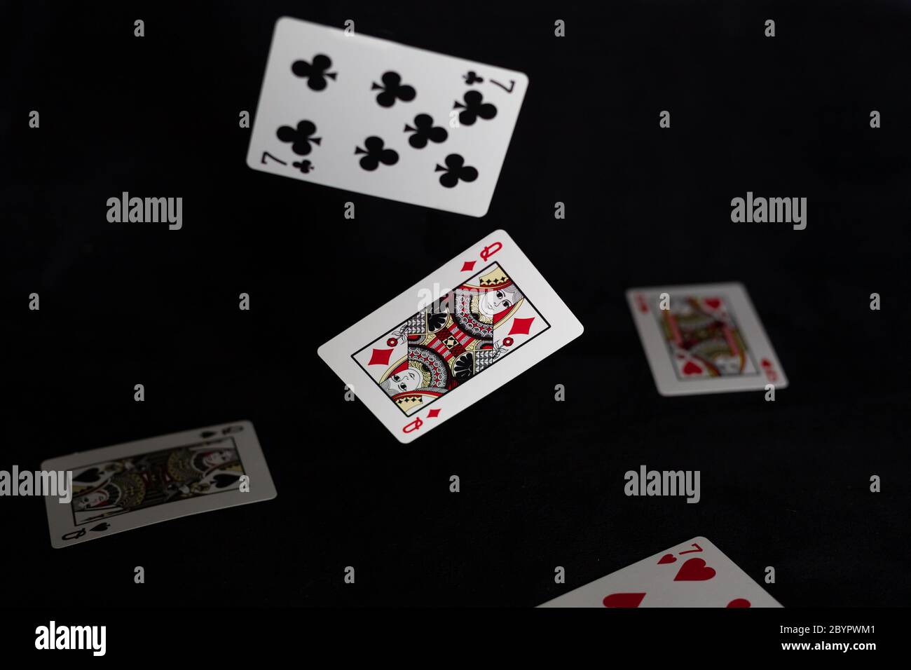 Schwebende Spielkarten auf schwarzem Hintergrund Stockfoto