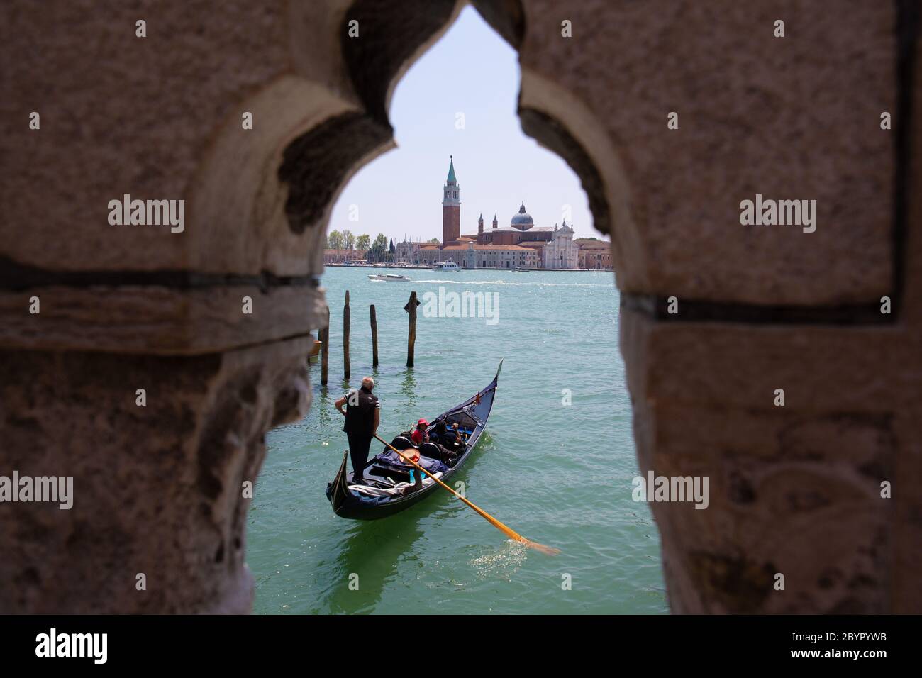 Ein Gondoliere rudert eine Gondel vor der Insel San Giorgio Maggiore, Lagune von Venedig, Italien Stockfoto