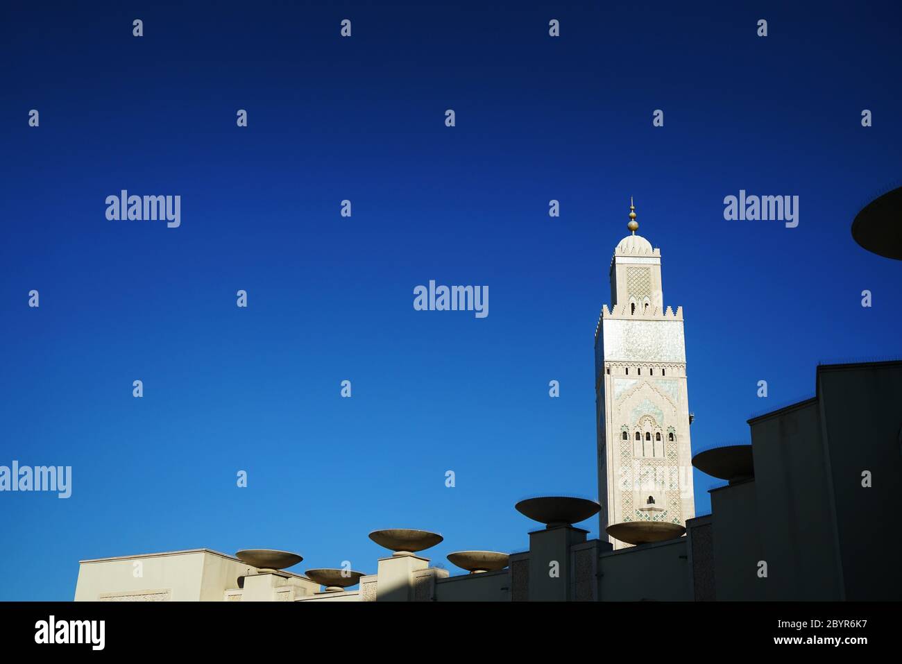 Das 60-stöckige Minarett der Hassan II. Moschee (umgangssprachlich als "Casablanca Hajj" bekannt) ist im Bogen des Gehwegs in Casablanca, M, eingerahmt Stockfoto