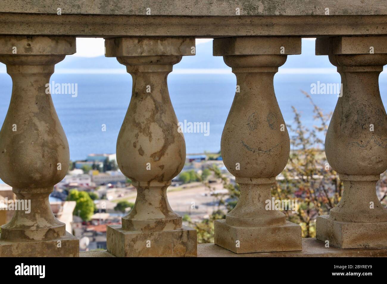 Verlassene alte Stein Baluster Geländer mit Stadtbild im Hintergrund Stockfoto