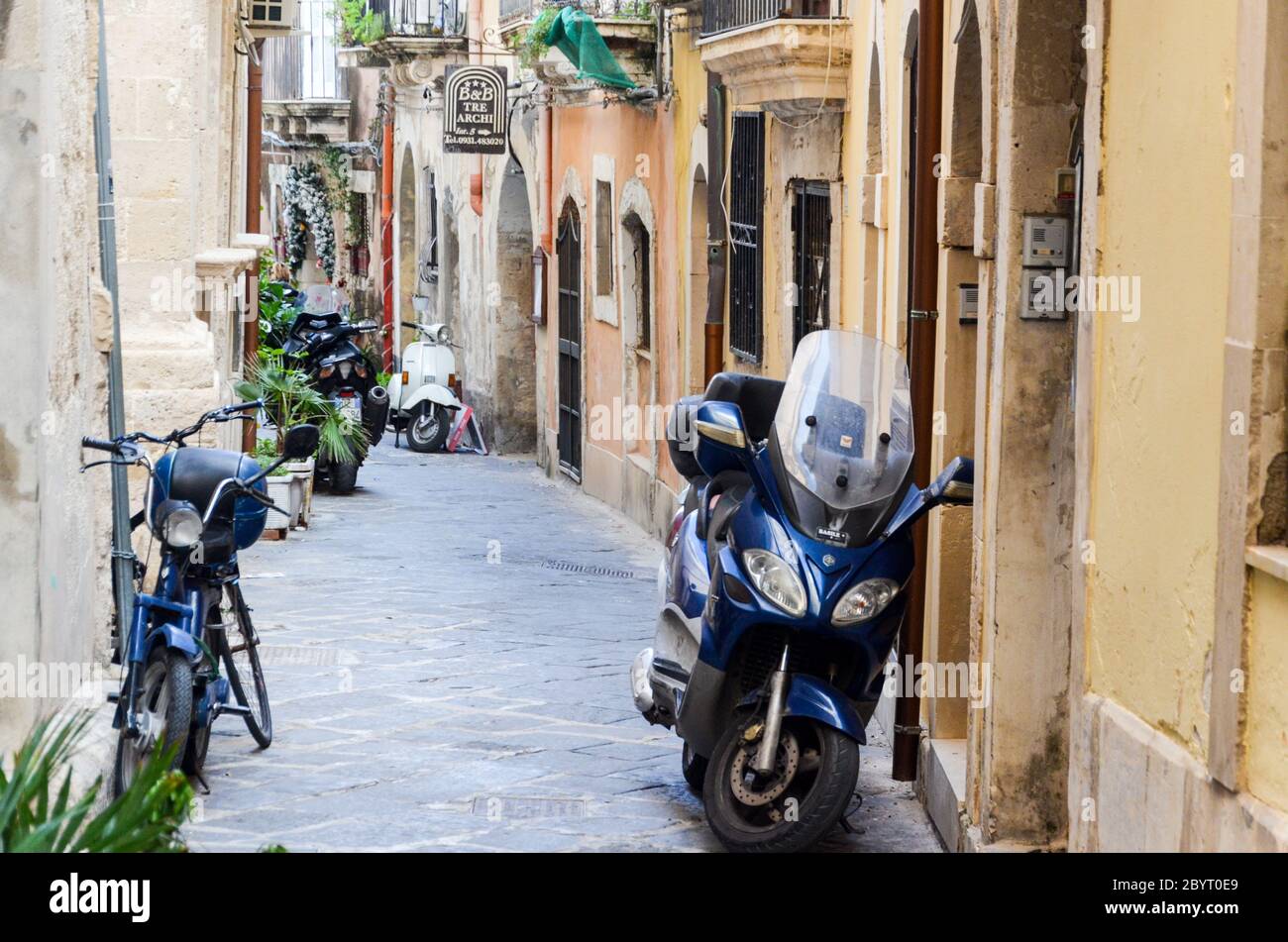 Vespas und Roller, Straßenleben in Ortigia, Syrakus, Sizilien, Italien Stockfoto