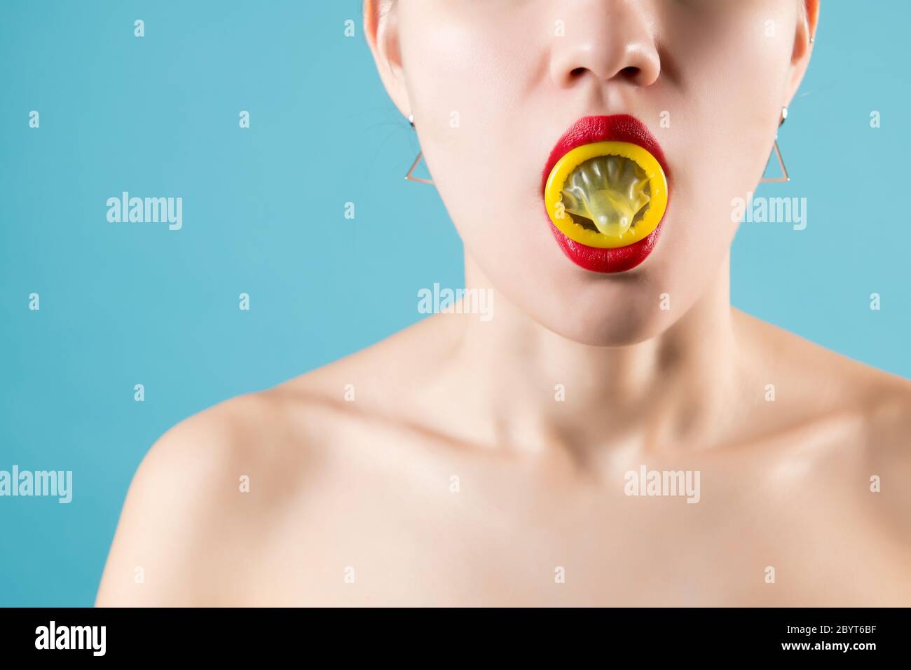 Mädchen hält ein rotes Kondom mit roten Lippen, Nahaufnahme Stockfoto